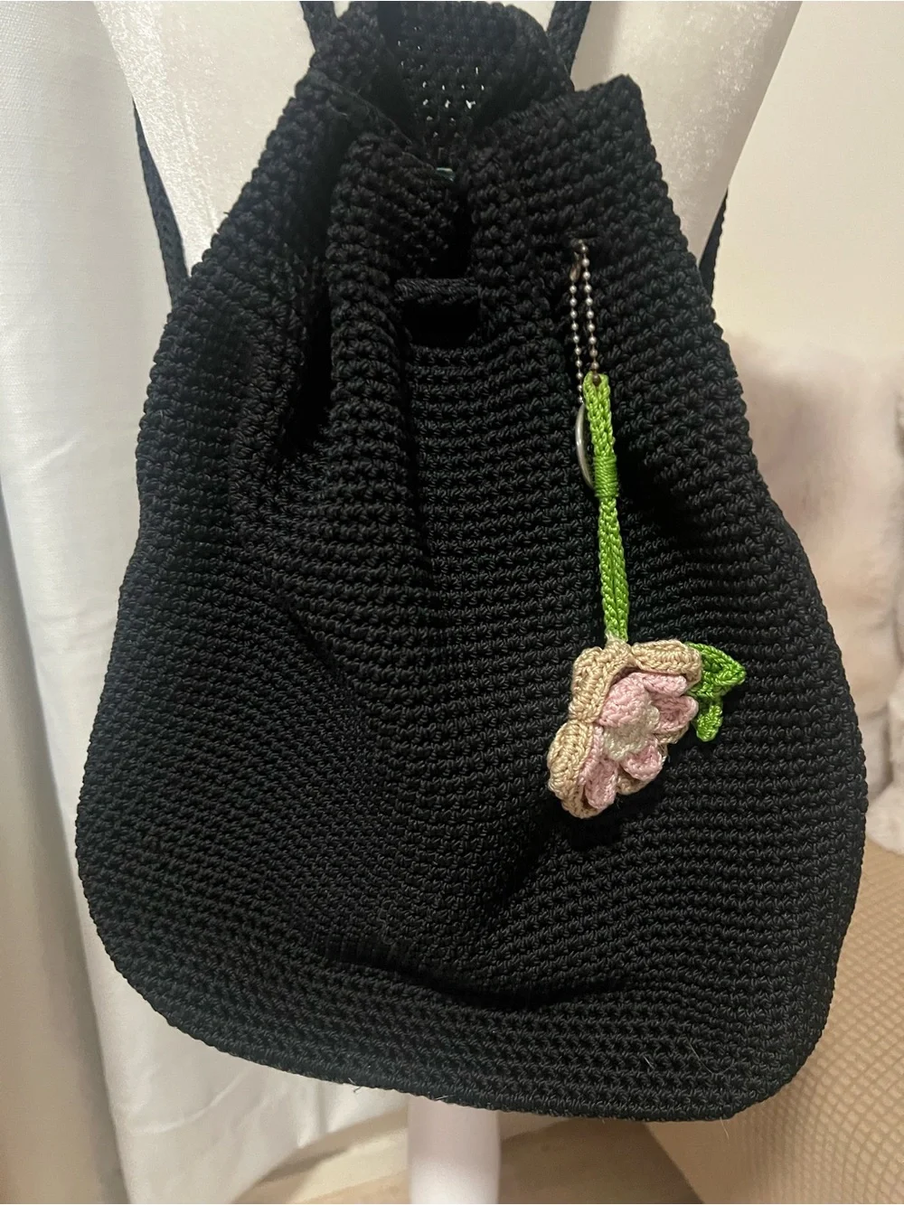 The Sak Black Knit Drawstring Backpack with Pink Floral Charm